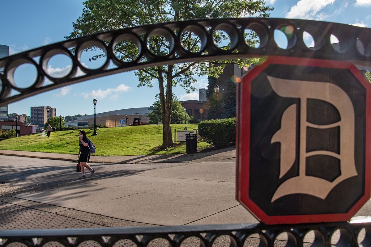 DU logo in the foreground of the campus shot